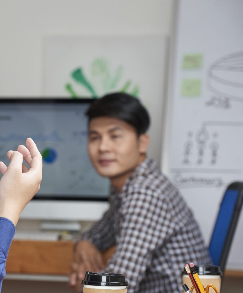 Cropped image of young businessman telling his idea to coworkers at meeting